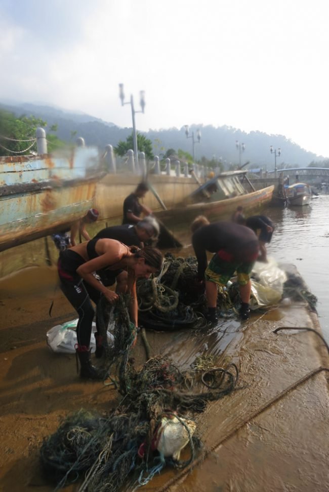 Struggling to pull the trash up the slippy jetty